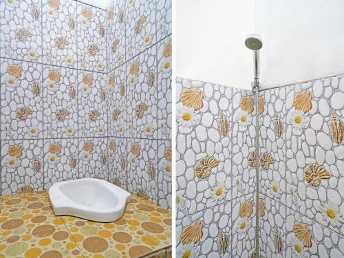 a bathroom with a toilet and a tiled wall at SPOT ON 91993 Pondok Hs Padalarang Syariah in Padalarang