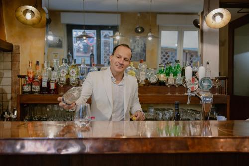 a man standing at a bar making a drink at Locanda Milano 1873 in Brunate