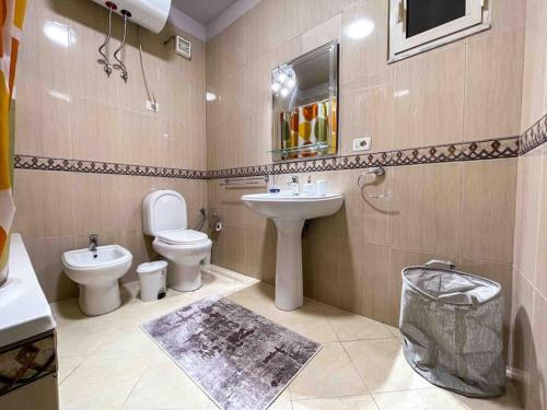 uma casa de banho com um lavatório, um WC e um espelho. em Downtown Flat near Center with 24h Self Check-In em Tirana