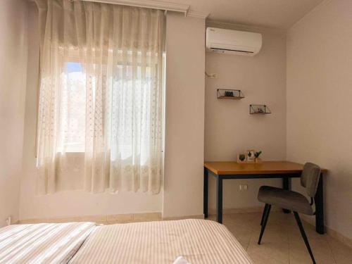 um quarto com uma secretária, uma cama e uma janela em Downtown Flat near Center with 24h Self Check-In em Tirana