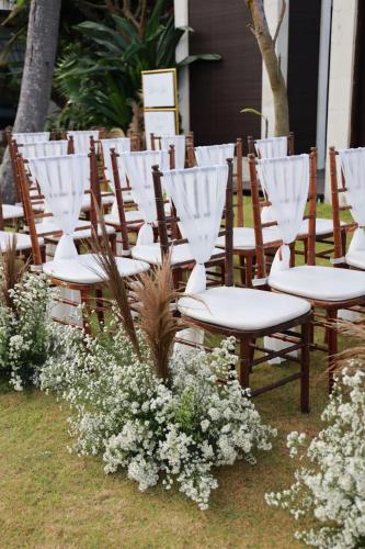 a row of chairs with white curtains and flowers at Villa Samudra Luxury Beachfront in Ketewel