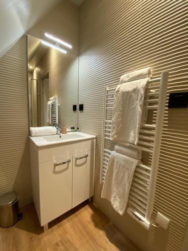 bagno con lavandino bianco e specchio di L'Huitrière a Quiberville