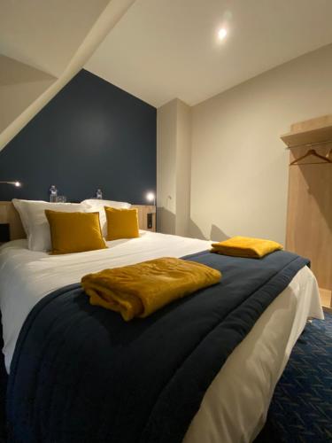 a bedroom with a large bed with yellow pillows at L'Huitrière in Quiberville