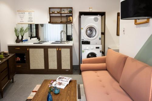 a living room with a couch and a kitchen at Quang Vinh Apartment and Hotel Hoi An in Hoi An
