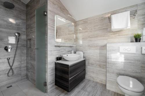 a bathroom with a sink and a toilet and a shower at Villa Oslo - luxury place with sea views & heated pool, 300m far from sandy beach in Omiš