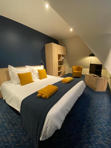 a bedroom with a large bed with yellow pillows at L'Huitrière in Quiberville