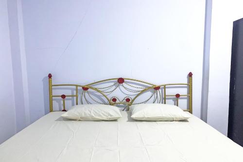 1 cama con 2 almohadas en una habitación en OYO 92002 Wisma Samudra, en Pangkajene