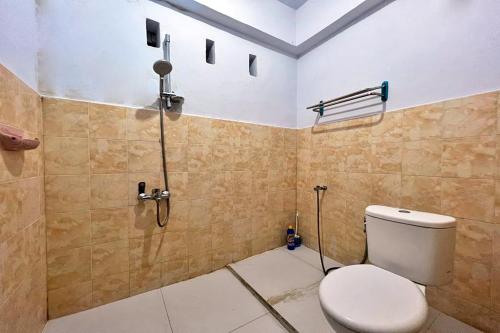 a bathroom with a toilet and a shower at OYO 92002 Wisma Samudra in Pangkajene