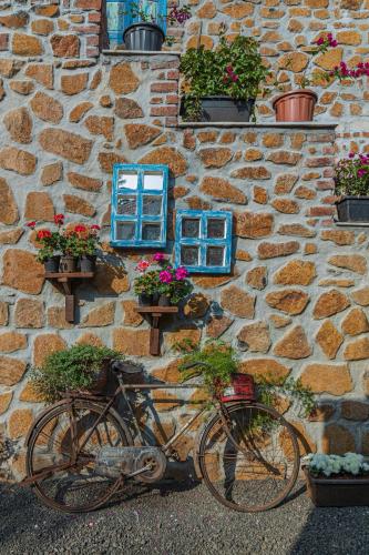 a bike parked in front of a stone wall with flowers at SaffronStays Lake House Marigold, Nashik - rustic cottages with private plunge pool in Nashik
