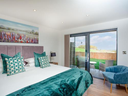 a bedroom with a large bed and a large window at Foxglove-uk34612 in Nether Stowey