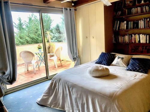 a bedroom with a bed and a large window at Sérénity Chambre d'hôte au calme Des Maîtres Tibétains y ont sejourné 15 mn des plages in Mougins
