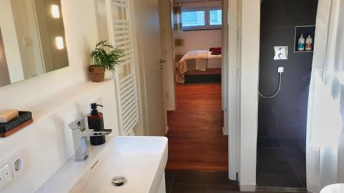 a bathroom with a white sink and a hallway at Donauhosting, Stadt Land Fluss in Unterkirchberg