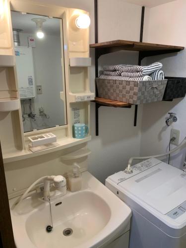 a bathroom with a sink and a washing machine at Creative　apartment in Kita-sanjō