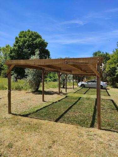 a wooden pavilion with a car parked under it at Casa Das Palmeiras-Pedagogic Farm in Mangualde