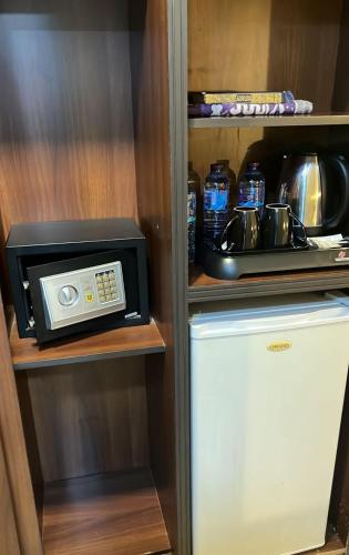 a microwave and a refrigerator in a kitchen at Abraj Al Tayseer Tuwa Hotel in Makkah