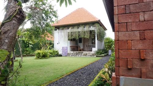 a house with a garden with a grass yard at Louto Dmell Villa & Guesthouse in Sanur