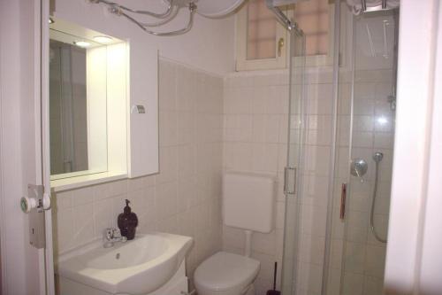 y baño con aseo, lavabo y ducha. en Vittoria Apartment, en Venecia