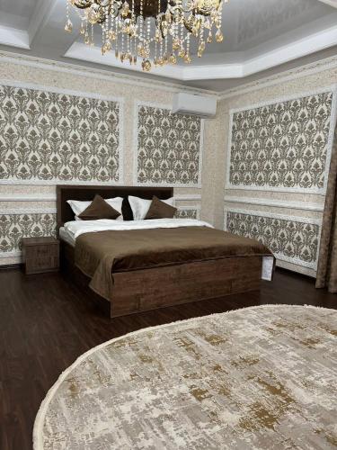 sypialnia z dużym łóżkiem i żyrandolem w obiekcie Grand SPA Hotel w mieście Kustanaj