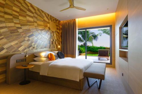 a bedroom with a large bed and a large window at SUN & MOON, Riverside Hotel in Phnom Penh