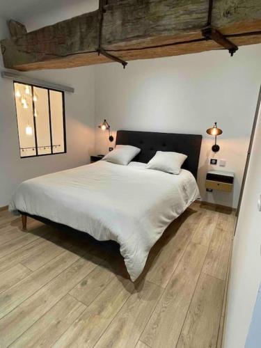 - une chambre avec un grand lit blanc et 2 oreillers dans l'établissement Maison Meursault parking fermé, à Meursault