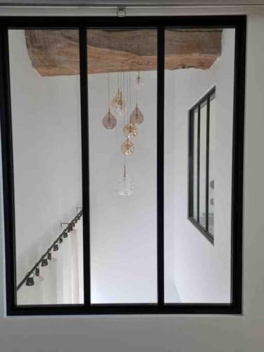 a room with two windows and some chandeliers at Maison Meursault parking fermé in Meursault