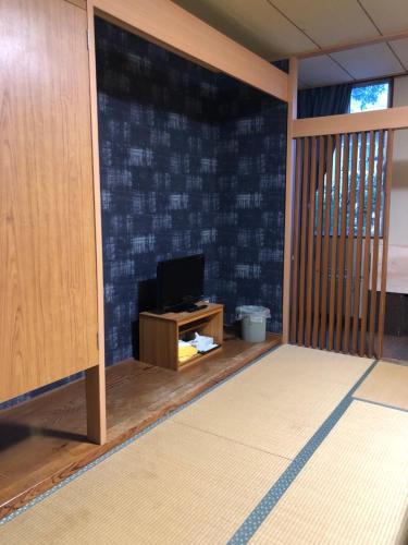 a room with a tv and a desk with a tvicterictericter at Petit Hotel Yukikkoso in Yuzawa