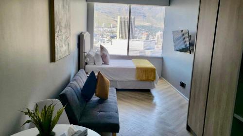 a living room with a bed and a couch in a room at 1728 at One Thibault in Cape Town
