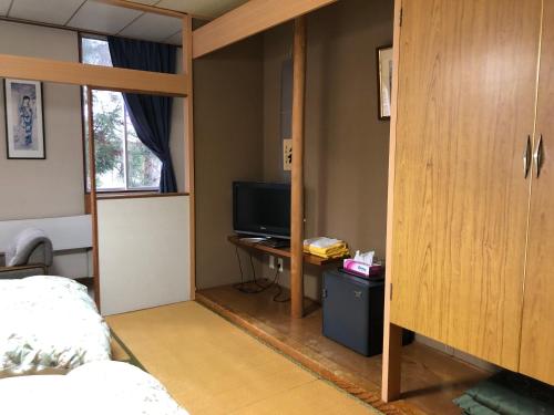 a bedroom with a bunk bed and a television at Petit Hotel Yukikkoso in Yuzawa
