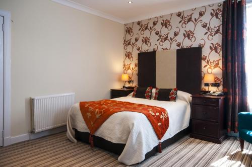 a bedroom with a large bed and a blue chair at South Beach Hotel in Troon