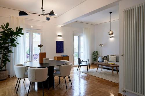 uma sala de estar com mesa e cadeiras em Mandra Living-Kolonaki em Atenas