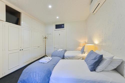 a bedroom with two beds with blue pillows at Peel Inn Hotel Nundle in Nundle