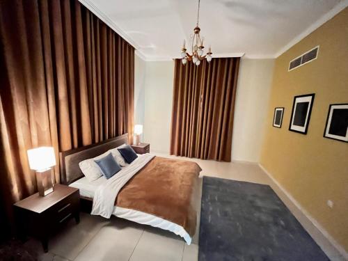 a bedroom with a large bed and a chandelier at Independent Spacious 3 Bedroom Villa in Dubai