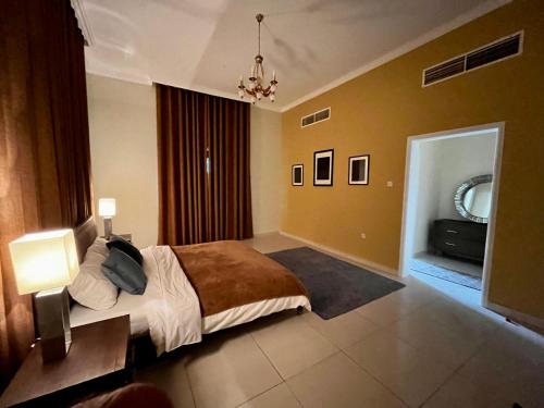 a bedroom with a bed and a television in it at Independent Spacious 3 Bedroom Villa in Dubai