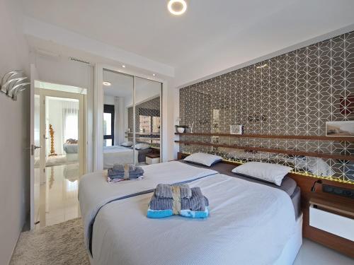 a bedroom with a large bed with towels on it at Beachfront Luxury Apartments in Arenales del Sol