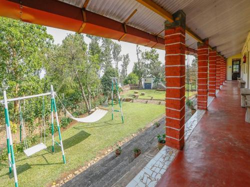 a porch with a playground with a swing at DEVASHOLA HOMESTAY in Coonoor
