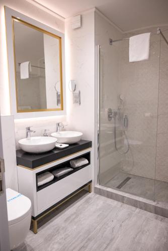a bathroom with two sinks and a glass shower at Queen Palace in Novi Sad