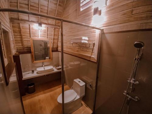 a bathroom with a toilet and a sink at The Blooms Villas in Bedugul