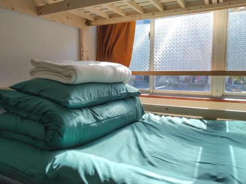 大阪市にあるGuest House miiの窓付きの客室のベッドに枕が備わります。