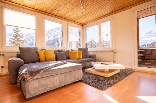 a living room with a couch and some windows at Miraflor Rosita - Arosa Holiday in Arosa