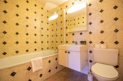 łazienka z toaletą, umywalką i wanną w obiekcie Miraflor Rosita - Arosa Holiday w mieście Arosa