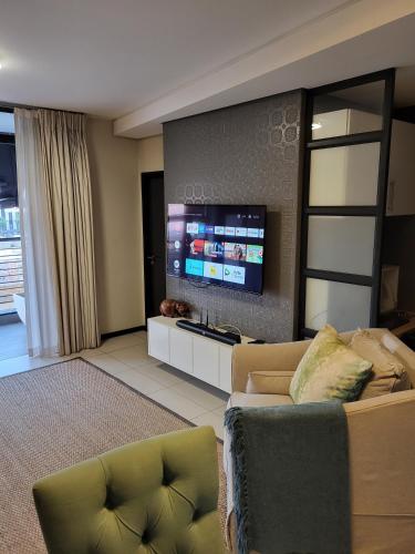 a living room with a couch and a flat screen tv at Easy Stay - The Vantage Rosebank in Johannesburg