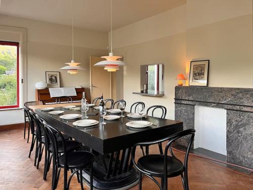 a dining room with a large black table and chairs at Villa Michaux in Hastière-par-delà