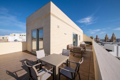 a balcony with tables and chairs on a building at Marea Boutique Hotels in Sliema