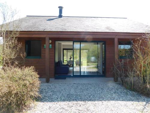 a house with sliding glass doors on it at Village de Gîtes Nature et Jardin in Bouère