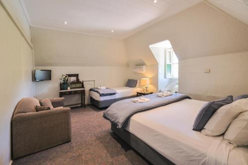 una camera d'albergo con due letti e una sedia di Peel Inn Hotel Nundle a Nundle