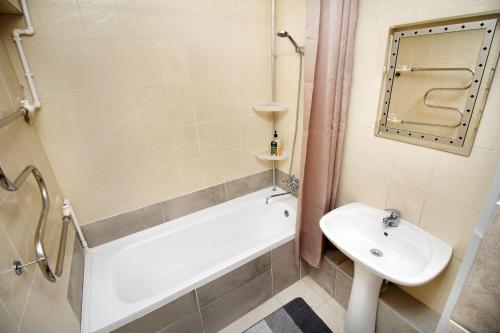 ein Badezimmer mit einem Waschbecken, einer Badewanne und einem WC in der Unterkunft Комфортные двухкомнатные апартаменты в центре Арбат, Макатаева 81 in Almaty