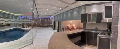 a kitchen and living room with a swimming pool at شاليه ريست 1 in Hail