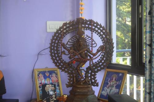 a statue of a skeleton in a room with pictures at Yoga House in McLeod Ganj