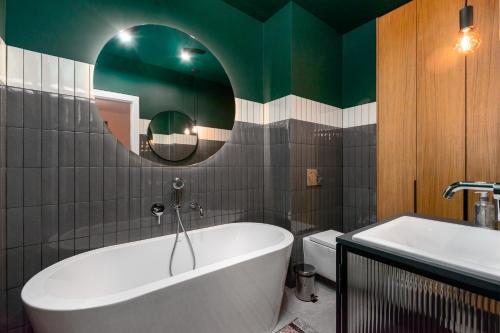a bathroom with a tub and a toilet and a mirror at Pory 57 by Homeprime in Warsaw