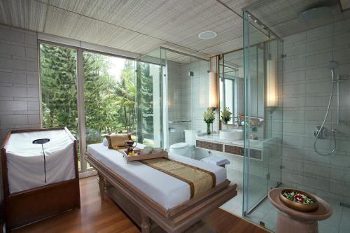 uma casa de banho com uma cama e uma cabina de duche em vidro em Mason Pine Hotel Bandung em Padalarang